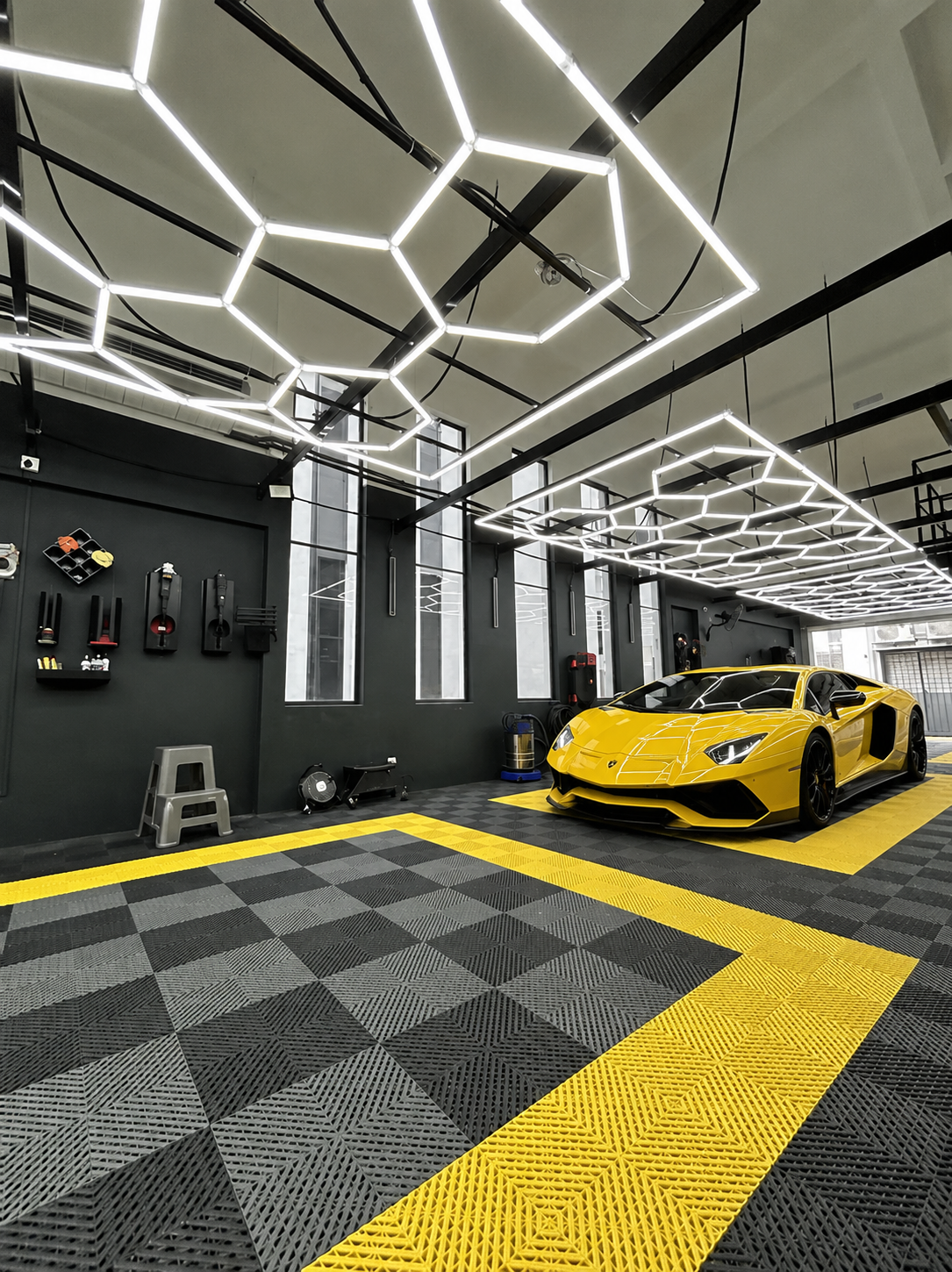 yellow Lamborghini in detailing room with checkerboard pattern on the floor